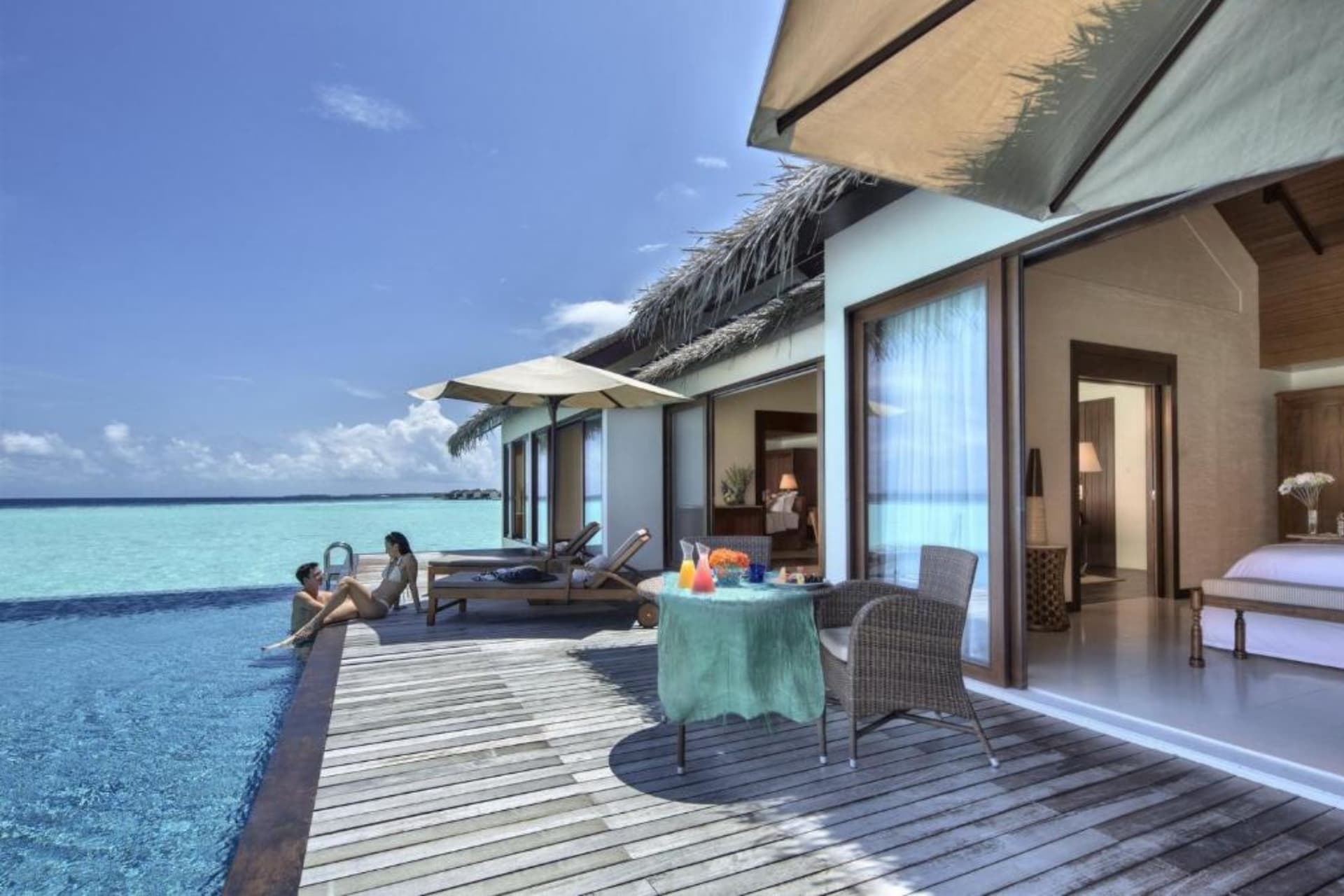 parella a la pisicna de la seva habitació en un resort de maldives