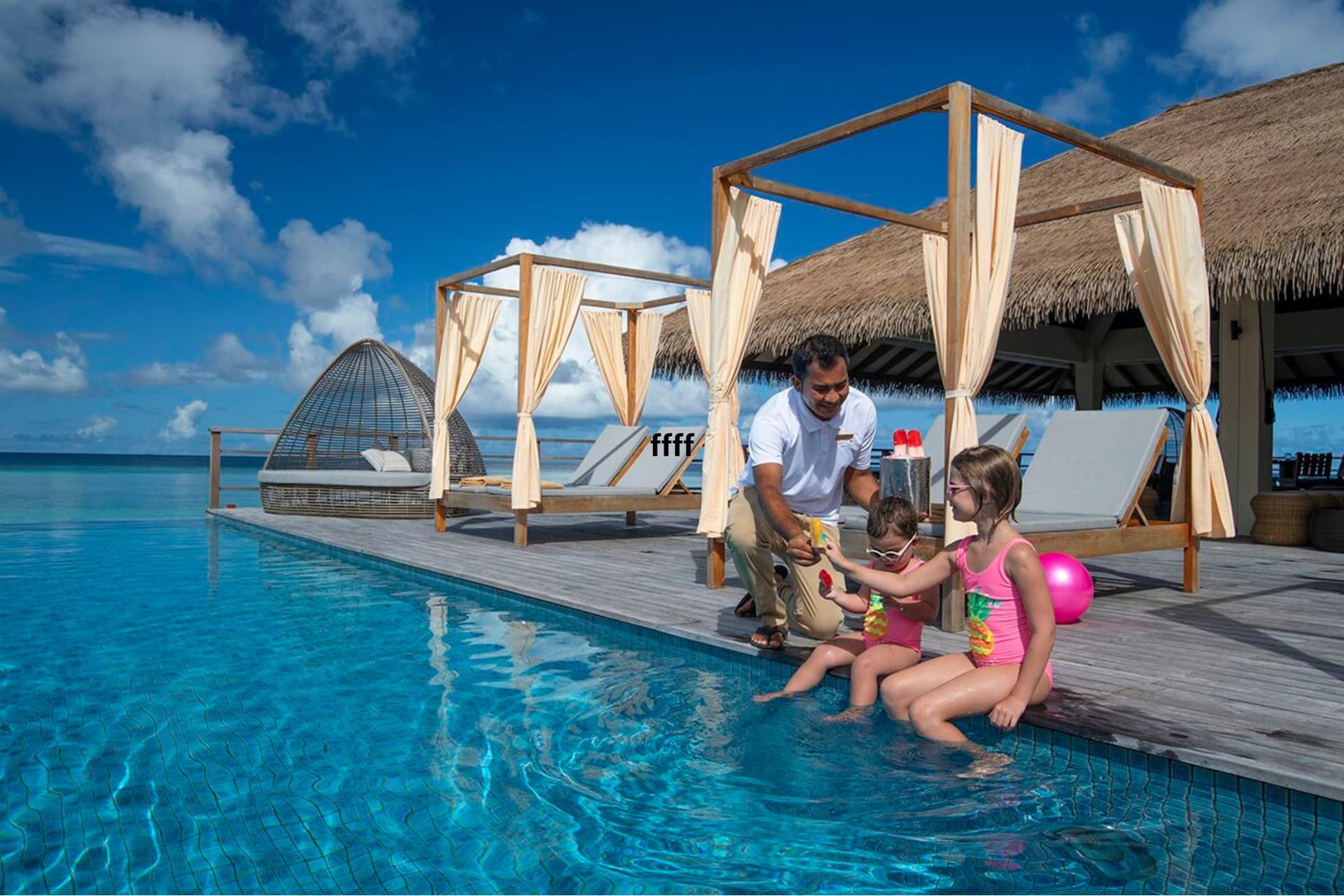 nens menjant gelat en una piscina en maldives